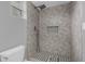 Modern bathroom shower with gray tiled walls and floor, and a shower niche at 1407 Dunsany Ave, Orlando, FL 32806