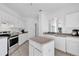 Spacious kitchen featuring white cabinets, tile floors, stainless steel appliances, and a center island at 142 Villa Di Este Ter # 204, Lake Mary, FL 32746