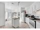 Bright kitchen features white cabinetry, tile floors, an island, and modern appliances at 142 Villa Di Este Ter # 204, Lake Mary, FL 32746