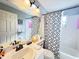 Bathroom featuring white cabinets, black fixtures, a white tiled shower, and a modern shower curtain at 146 Brad Cir, Winter Haven, FL 33880