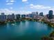 Expansive aerial view of a city skyline surrounding a tranquil lake with lush greenery and recreational areas at 150 E Robinson St # 1214, Orlando, FL 32801