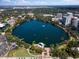 Expansive aerial view of a serene lake surrounded by lush green trees, parks, and modern city buildings at 150 E Robinson St # 1214, Orlando, FL 32801