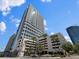 Beautiful high-rise building with a parking garage surrounded by well-maintained landscaping and palm trees at 150 E Robinson St # 1214, Orlando, FL 32801