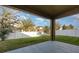 Covered back patio with a view of the lush green yard and white fence, perfect for outdoor relaxation and entertaining at 15174 Evergreen Oak, Winter Garden, FL 34787