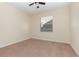 Bright, neutral bedroom with large window, tan carpet and off-white walls provide a calm space at 15174 Evergreen Oak, Winter Garden, FL 34787