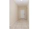Bright hallway with neutral walls and tiled flooring, leading to a white door at 15174 Evergreen Oak, Winter Garden, FL 34787