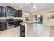 Well-lit kitchen featuring dark cabinetry, granite countertops, stainless steel appliances, and a view to the backyard at 15174 Evergreen Oak, Winter Garden, FL 34787