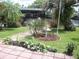 Serene backyard oasis with lush landscaping, charming birdbath, and a peaceful waterfront view at 1522 S Shore Dr, Tavares, FL 32778
