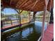 Covered boat dock featuring wooden beams, boatlift, protective netting, and scenic waterfront views at 1522 S Shore Dr, Tavares, FL 32778