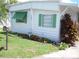 Charming home exterior featuring green shutters, tidy landscaping with orange flowers and a well-maintained lawn at 1522 S Shore Dr, Tavares, FL 32778