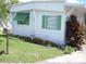 Charming home exterior featuring green shutters, tidy landscaping with orange flowers and a well-maintained lawn at 1522 S Shore Dr, Tavares, FL 32778