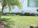 Landscaped front yard with vibrant orange flowers and a lush green lawn, providing a welcoming curb appeal at 1522 S Shore Dr, Tavares, FL 32778