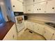 Cozy kitchen featuring white cabinetry, classic appliances, and neutral countertops at 1522 S Shore Dr, Tavares, FL 32778
