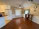 Open-concept living room with a ceiling fan, wood-look floors, and a view of the adjacent kitchen at 1522 S Shore Dr, Tavares, FL 32778