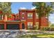 Two-story red townhouse with a black door, a garage and well-kept landscaping at 167 Villa Di Este Ter Ter # 213, Lake Mary, FL 32746