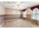 Empty bedroom features carpet flooring, floral wallpaper, two windows with coverings and a ceiling fan at 1709 Palm Beach Dr, Apopka, FL 32712