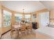 Sunlit dining area featuring a wooden table with chairs, a large window, and neutral wall colors at 1709 Palm Beach Dr, Apopka, FL 32712