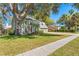 Beautiful exterior view of a home with a lush green lawn, mature trees, and a sidewalk at 1709 Palm Beach Dr, Apopka, FL 32712