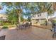 An expansive stone patio area features an outdoor dining set, a grill, and a view of the backyard at 1709 Palm Beach Dr, Apopka, FL 32712