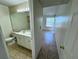 Hallway view of bathroom featuring double vanity, tile flooring, and a toilet at 1932 Lake Atriums Cir # 85, Orlando, FL 32839
