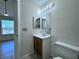 Bathroom with a single vanity, toilet, and mirror with decorative lighting at 1932 Lake Atriums Cir # 85, Orlando, FL 32839