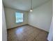 Bedroom featuring neutral walls, tile flooring, and natural light from the window at 1932 Lake Atriums Cir # 85, Orlando, FL 32839