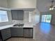 Bright kitchen with stainless steel dishwasher, double sink, gray cabinets, and white countertop at 1932 Lake Atriums Cir # 85, Orlando, FL 32839