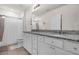 Well-lit bathroom featuring double sinks with granite countertops, and a shower with tiled walls and a glass door at 2234 Bluebird Pl, St Cloud, FL 34771