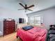 Cozy bedroom features a ceiling fan, hardwood floors, and a large window at 2263 Mallard Creek Cir, Kissimmee, FL 34743