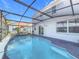A screened in pool and patio feature comfortable seating, ideal for outdoor relaxation and entertaining at 2263 Mallard Creek Cir, Kissimmee, FL 34743