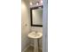 Small bathroom with a pedestal sink, tiled floor, and simple mirror with lighting at 2355 Seven Oaks Dr, St Cloud, FL 34772