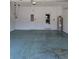 Spacious garage featuring a painted floor, water heater, and utility box near the door at 2355 Seven Oaks Dr, St Cloud, FL 34772