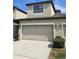 Beige two-car garage door of townhome with overhead light, address numbers, and landscaping at 2355 Seven Oaks Dr, St Cloud, FL 34772