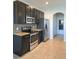 Modern kitchen features stainless steel appliances, dark cabinetry, and granite countertops, offering a stylish cooking space at 2355 Seven Oaks Dr, St Cloud, FL 34772