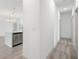 Bright hallway with wood-look flooring leading to a modern kitchen featuring stainless steel appliances at 2531 Sw 167Th Loop, Ocala, FL 34473