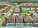 Aerial view displays backyard pools, lush landscaping, and a serene pond within the residential community at 2551 Dharma Cir, Kissimmee, FL 34746