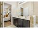 This bathroom view looks into the bedroom, highlighting the double sinks and dark wood cabinet at 2551 Dharma Cir, Kissimmee, FL 34746