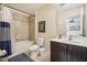 Bathroom featuring a shower-tub combo with tiled surround and a dark-stained vanity at 2551 Dharma Cir, Kissimmee, FL 34746