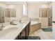 Bathroom featuring double sinks with a dark wood cabinet, a bathtub, and two glass-doored showers at 2551 Dharma Cir, Kissimmee, FL 34746