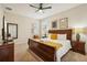 This bedroom features a ceiling fan, a wood-framed bed, and decorative prints on the wall at 2551 Dharma Cir, Kissimmee, FL 34746