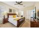 The bedroom features neutral walls, a ceiling fan, a dresser with a TV, and a dark wood bed frame at 2551 Dharma Cir, Kissimmee, FL 34746