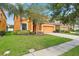 Well-maintained two-story home with green lawn, mature landscaping, and attached garage at 2551 Dharma Cir, Kissimmee, FL 34746