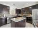 Modern kitchen featuring granite countertops, stainless steel appliances, and dark wood cabinetry at 2551 Dharma Cir, Kissimmee, FL 34746