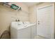 Functional laundry room equipped with a washer, dryer, storage shelf and utility door at 2551 Dharma Cir, Kissimmee, FL 34746
