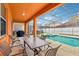 Covered patio area with a dining table, grill, and access to the screened pool and backyard at 2551 Dharma Cir, Kissimmee, FL 34746