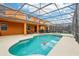 A screened-in pool with a built-in hot tub and a patio, perfect for relaxation and recreation at 2551 Dharma Cir, Kissimmee, FL 34746