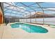 A screened-in pool with a built-in hot tub and white fences and a screen enclosure at 2551 Dharma Cir, Kissimmee, FL 34746