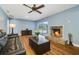 Inviting living room featuring a brick fireplace, ceiling fan, and sliding doors to the outdoor pool at 2595 Sweetwater Trl, Maitland, FL 32751