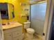 Bright bathroom with yellow walls, a vanity sink, toilet, and a shower with a glass door; perfect for everyday use at 281 San Gabriel St, Winter Springs, FL 32708