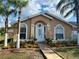 Inviting single-story home with meticulous landscaping and a welcoming front entrance with arched windows and a white door at 281 San Gabriel St, Winter Springs, FL 32708